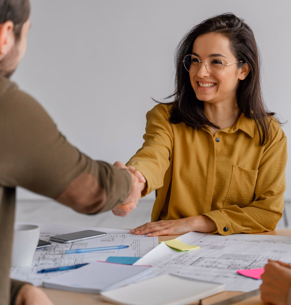 Senior lawyer shaking hands with a client at a desk