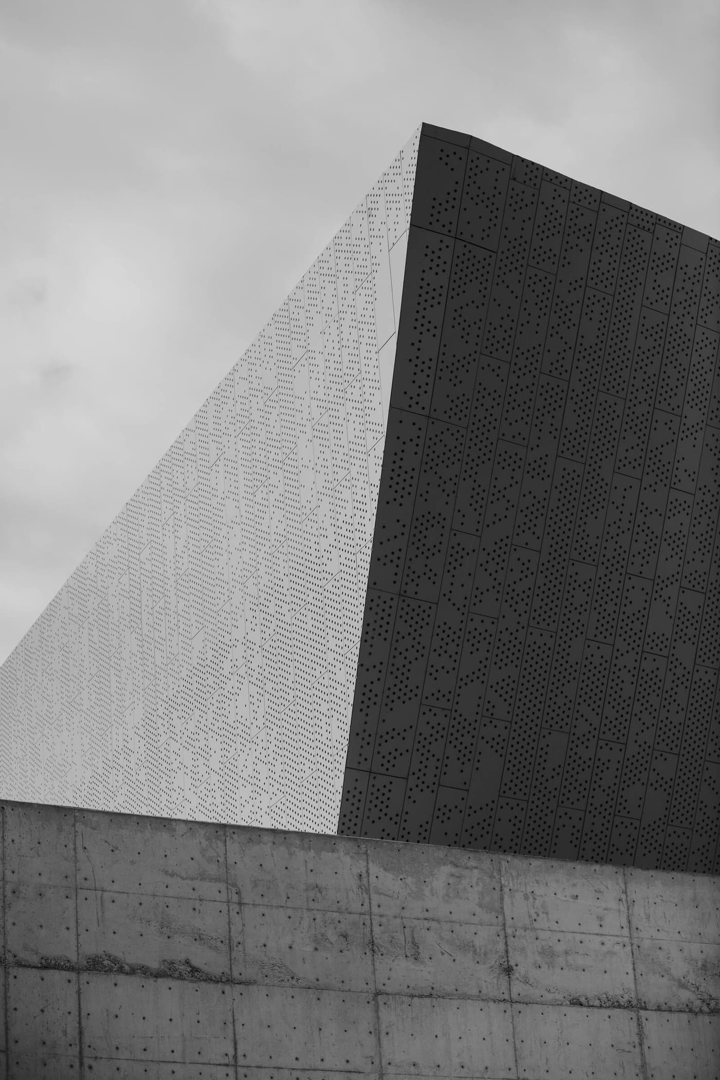 Modern architecture — two perforated facades meeting at a sharp edge